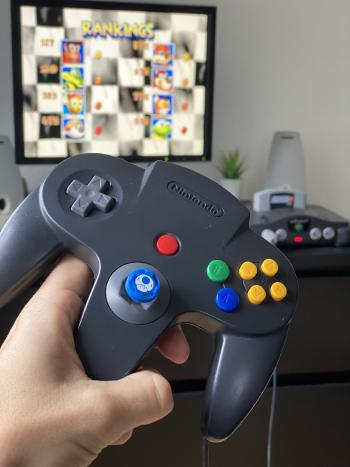 Nintendo 64 controller with gaming in the background